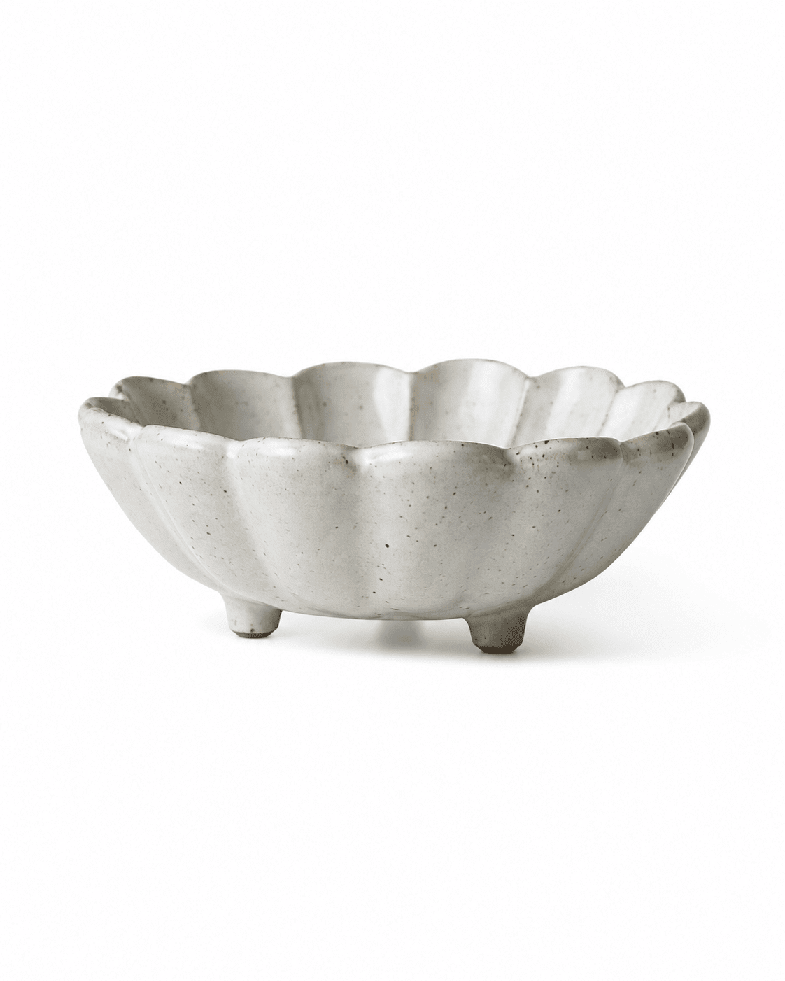 Side view of handmade white speckled footed ceramic flower bowl with scalloped rim