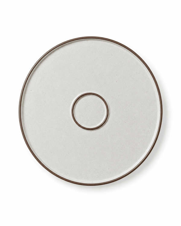Bottom view of a speckled ceramic dinner plate with brown rim and circular foot ring