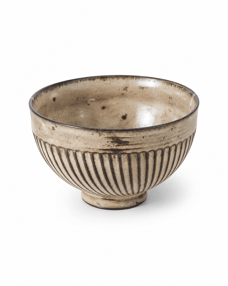 Japanese style handcrafted ribbed ceramic rice bowl with beige and brown reactive glaze isolated on a clean white background