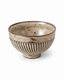 Japanese style handcrafted ribbed ceramic rice bowl with beige and brown reactive glaze isolated on a clean white background