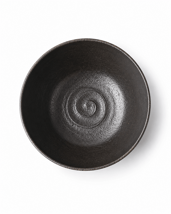 Black ceramic serving bowl top view with spiral interior texture
