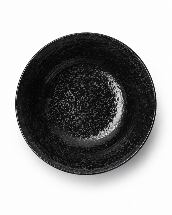 Top view of handmade black reactive glaze stoneware bowl showing glossy speckled interior and textured finish