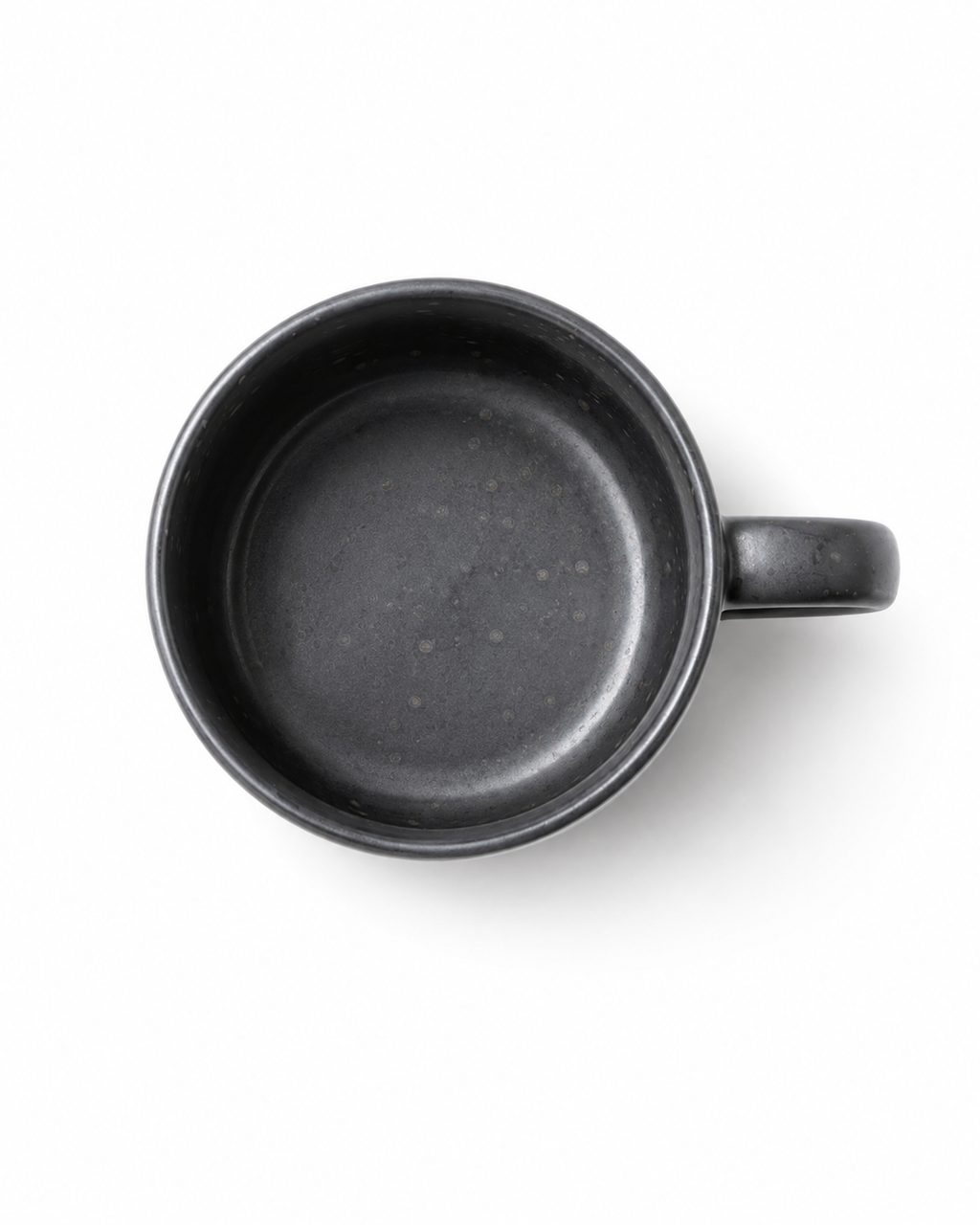 Top view of a handmade black stoneware coffee mug showing the matte speckled ceramic interior