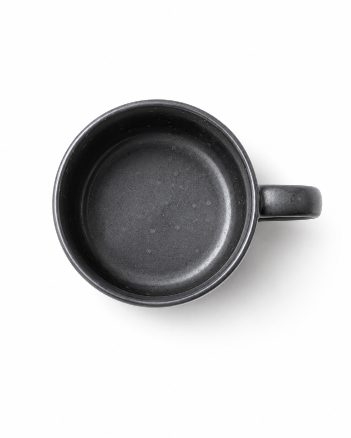 Top view of a handmade black stoneware coffee mug showing the matte speckled ceramic interior