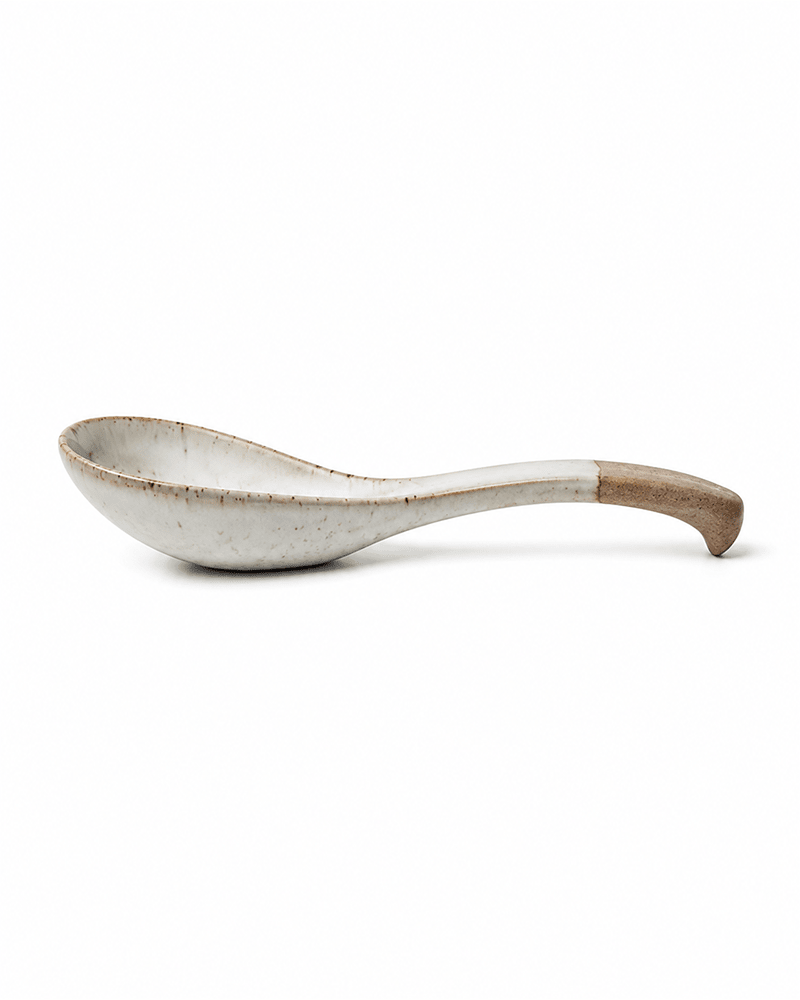 Ceramic soup spoon with natural clay handle shown in side view