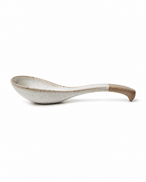 Ceramic soup spoon with natural clay handle shown in side view
