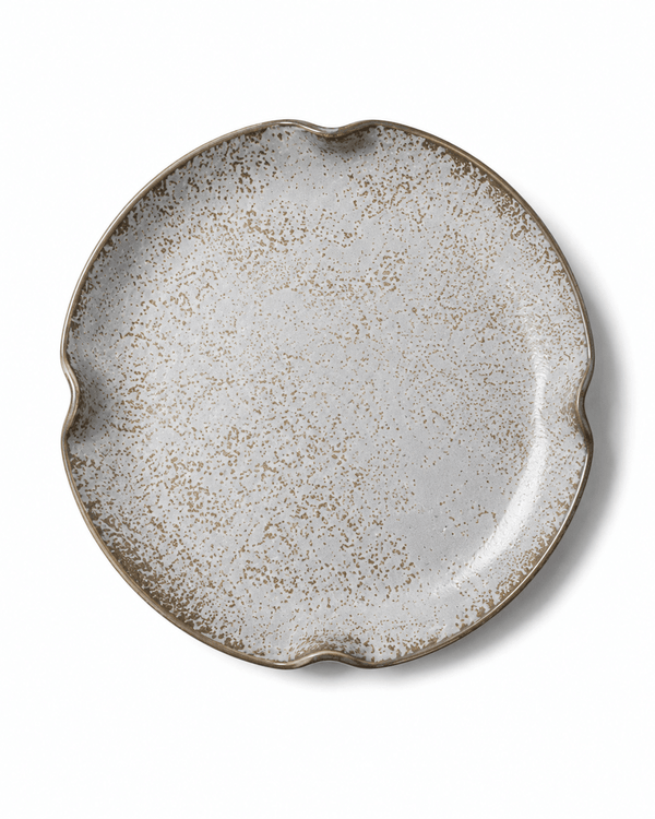 Top view of grey white speckled reactive glaze ceramic plate with brown detailing and four-point irregular rim
