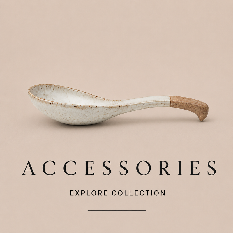 A ceramic serving spoon with a speckled off-white glaze and a natural wood handle