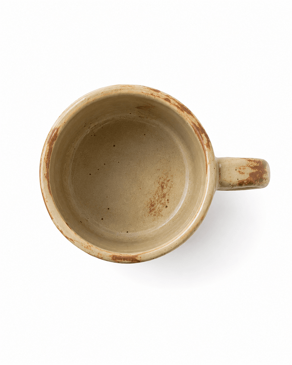 Top view of handmade beige stoneware mug showing speckled reactive glaze interior and rustic brown rim