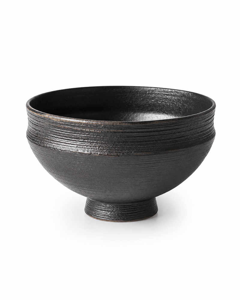 Handmade black ceramic serving bowl with textured finish and footed base