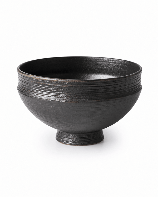 Handmade black ceramic serving bowl with textured finish and footed base