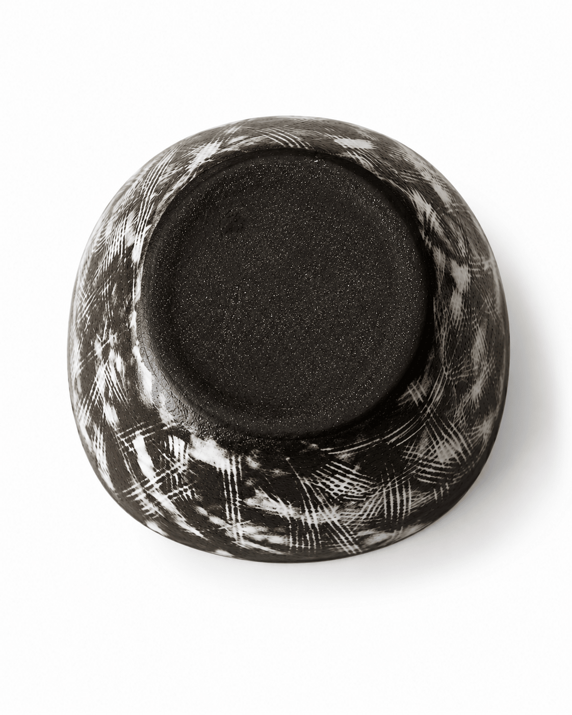 Bottom view of handmade black floral ceramic bowl showing the dark ceramic base and white brush pattern