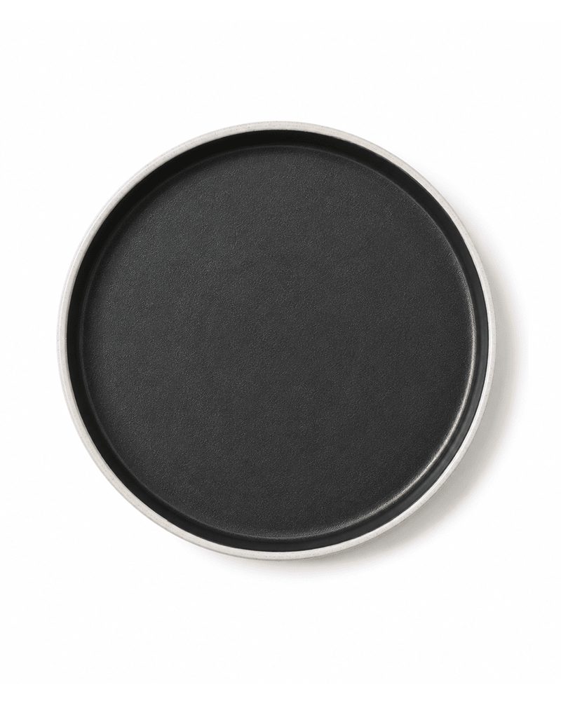 Top view of handmade ceramic dinner plate with matte black interior and speckled grey rim