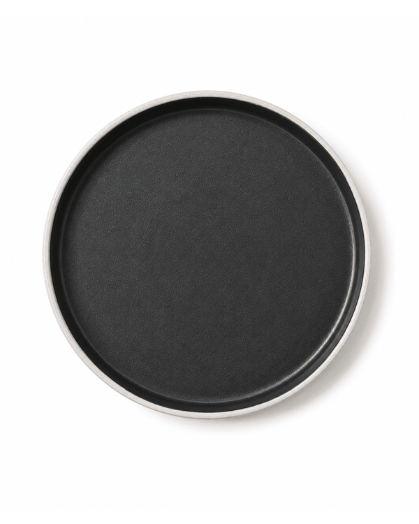 Top view of handmade ceramic dinner plate with matte black interior and speckled grey rim