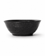 Side view of handmade black reactive glaze stoneware bowl with flared rim, textured fini