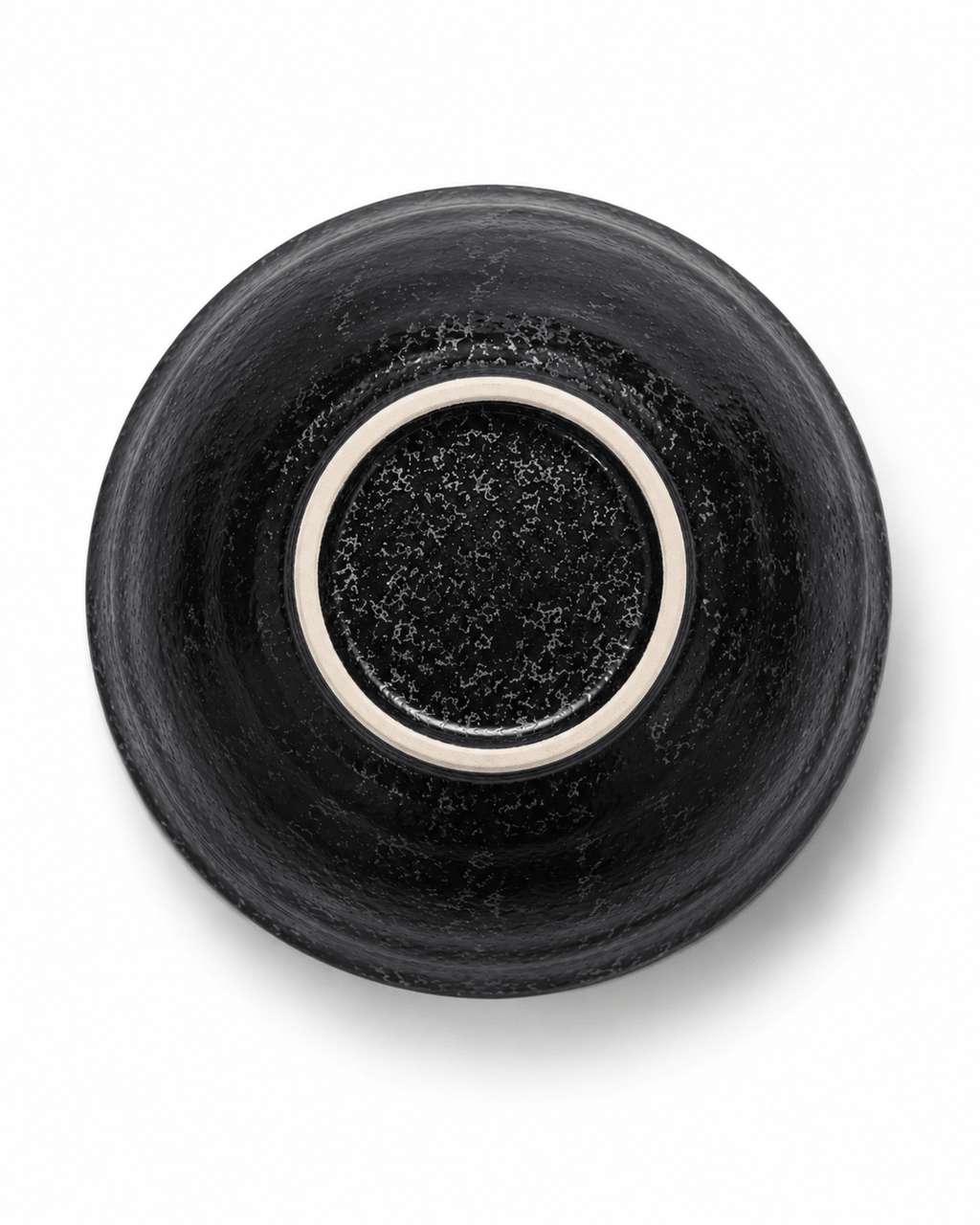 Bottom view of handmade black stoneware bowl showing reactive glaze finish and unglazed ceramic foot ring