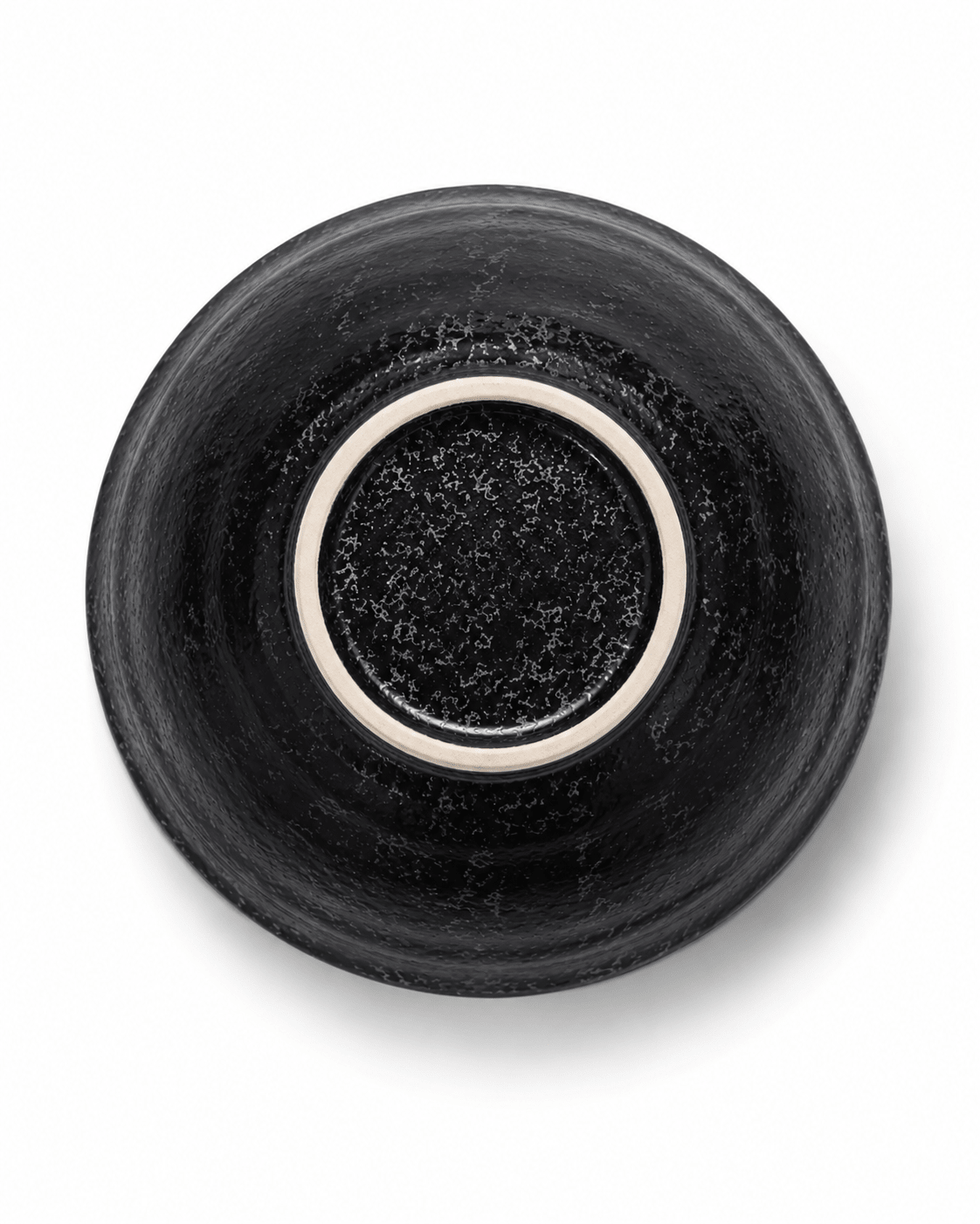 Bottom view of handmade black stoneware bowl showing reactive glaze finish and unglazed ceramic foot ring