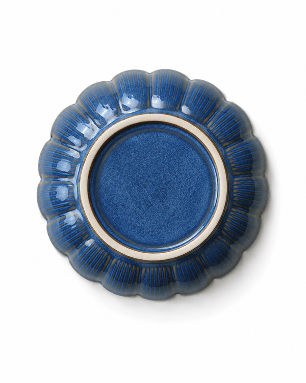 Bottom view of handmade blue glazed ceramic soy sauce dish with scalloped floral edge and unglazed foot ring