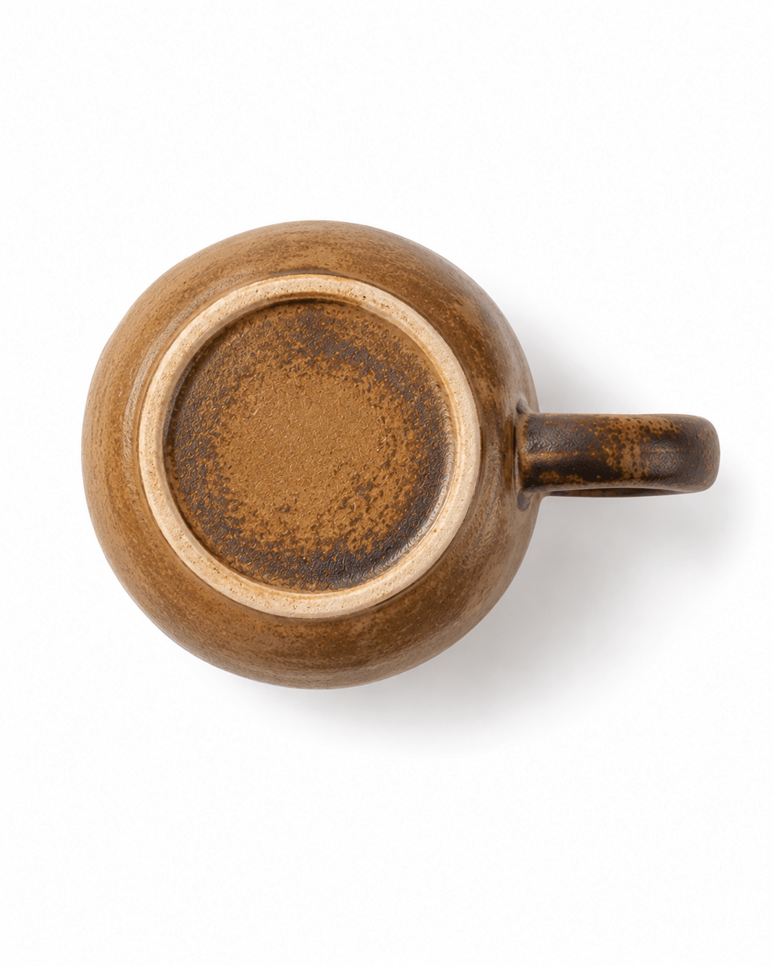 Bottom view of a handmade brown ceramic mug showing the unglazed foot and natural reactive glaze