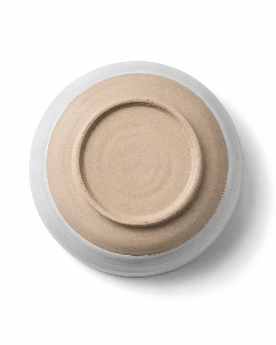 Bottom view of handmade ceramic bowl showing the natural beige clay base, circular foot ring and white glazed exterior