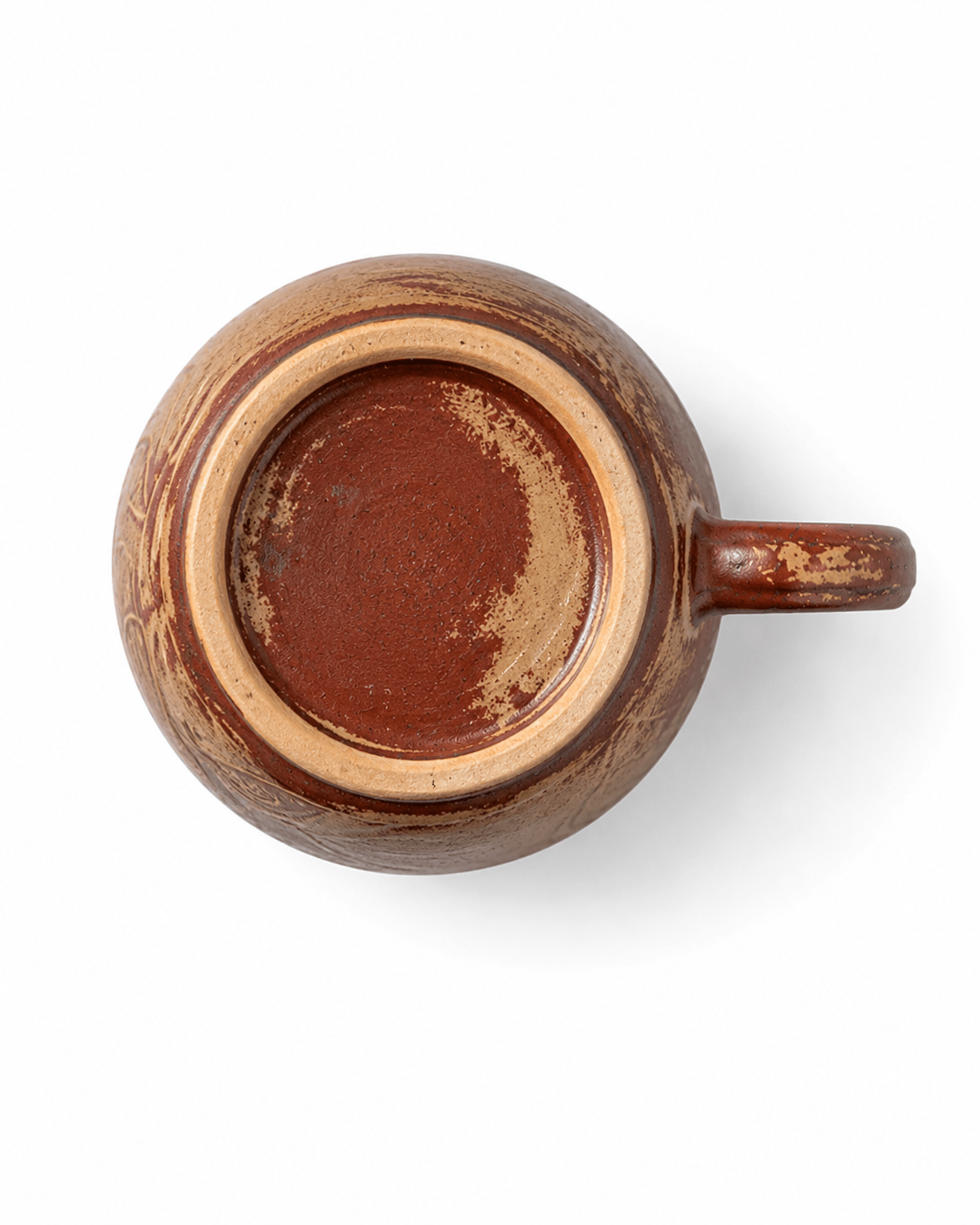 Bottom view of a handmade red brown ceramic mug showing the natural unglazed foot ring and reactive glaze