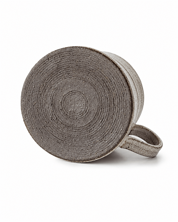 Handmade ceramic mug with textured wheel-thrown base