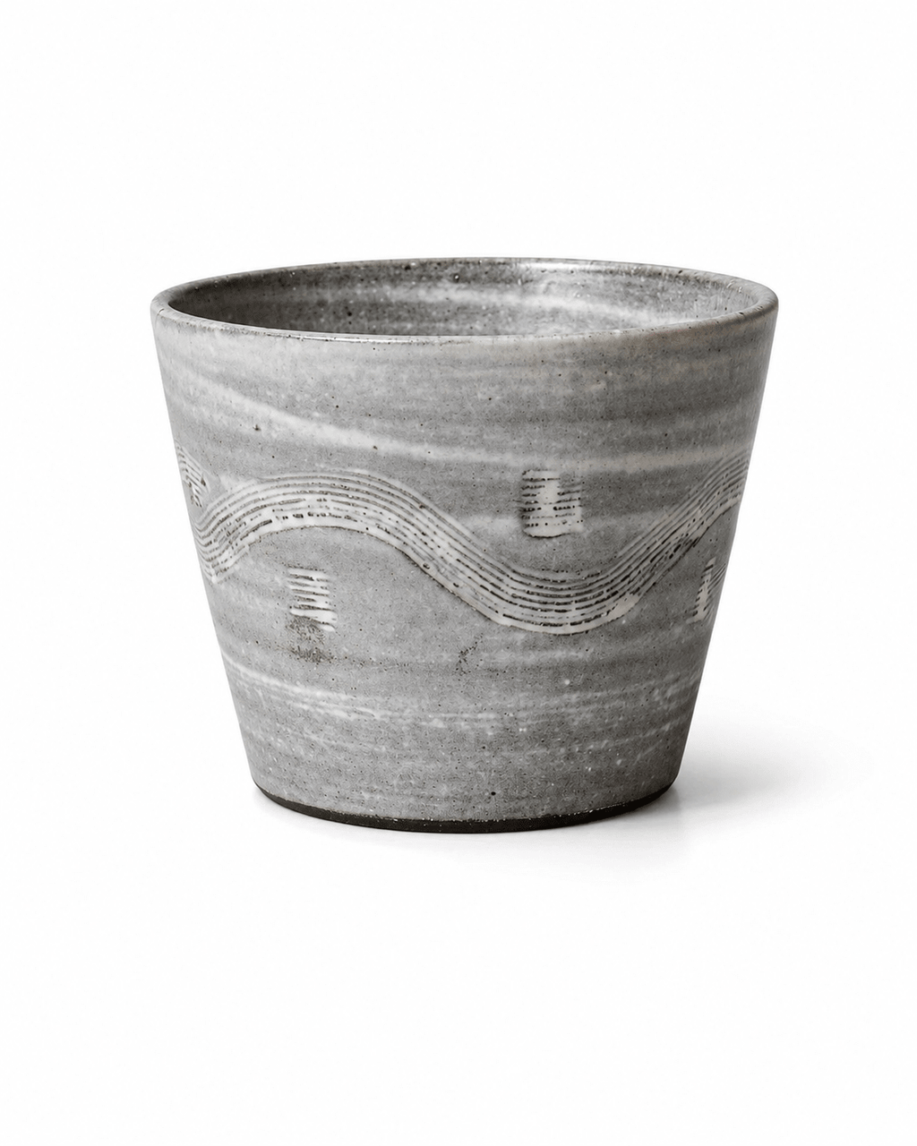 Handmade grey reactive glaze stoneware tumbler with white carved wave pattern and handleless design
