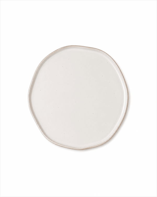 Top view of handmade ivory white ceramic dinner plate with organic irregular shape and subtle speckled glaze