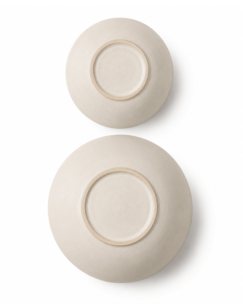 Base view of handmade off white ceramic pasta and cereal bowls showing the unglazed foot rings and natural ceramic texture