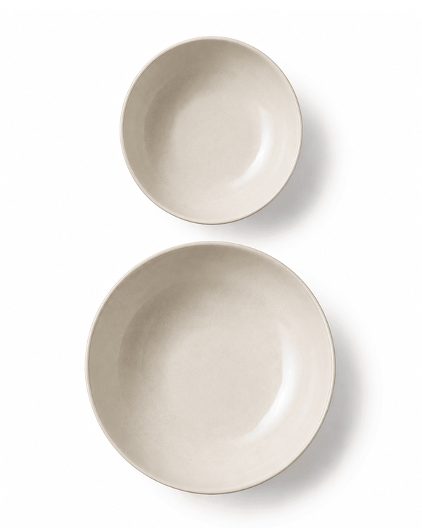 Top view of handmade off white ceramic pasta and cereal bowls showing the smooth glazed interiors and organic round shape