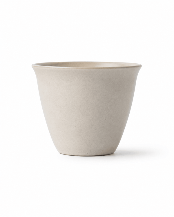 Front view of handmade off-white stoneware tea cup with a minimalist handleless design