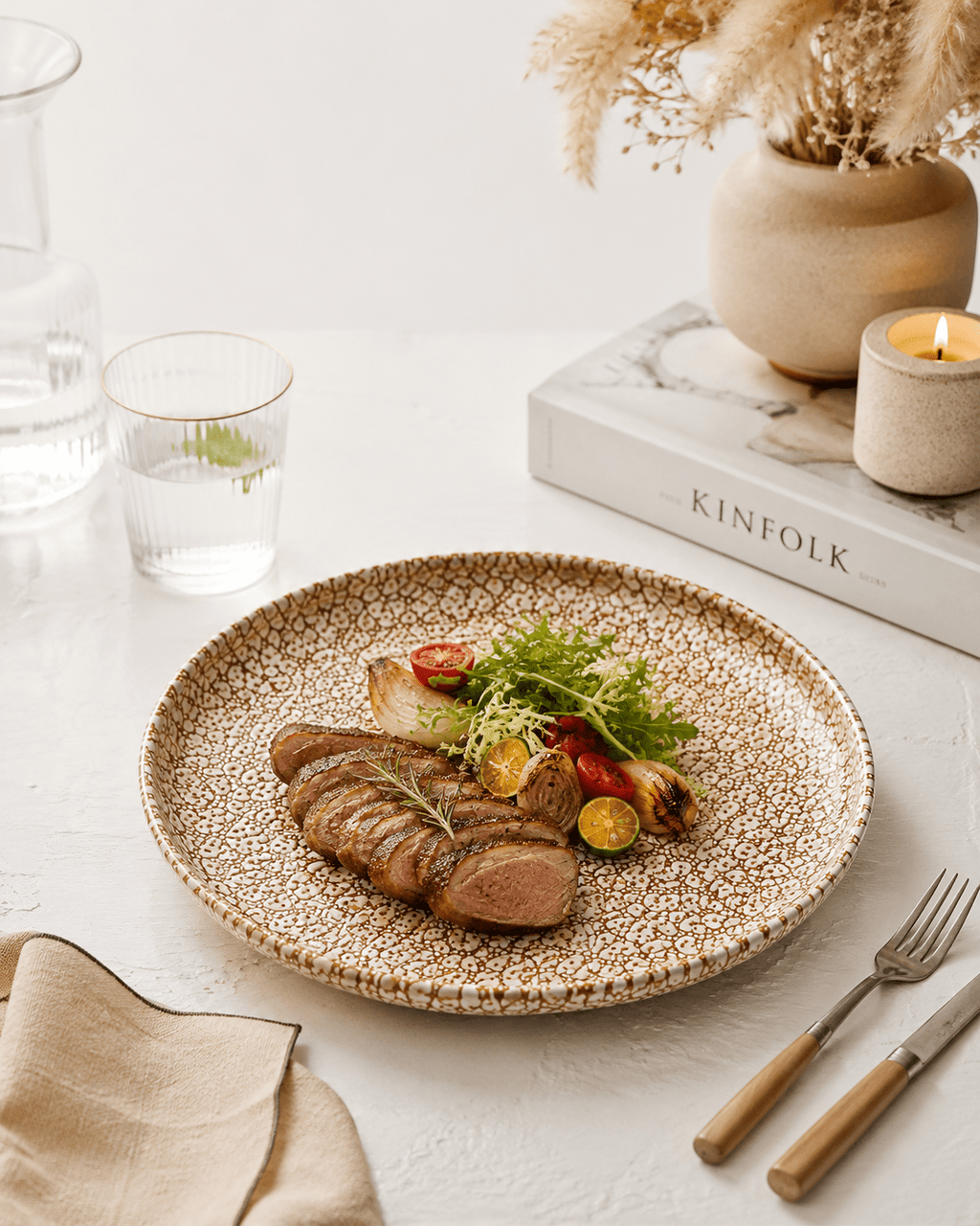 Handmade speckled stoneware dinner plate with grilled steak and vegetables on a neutral table setting