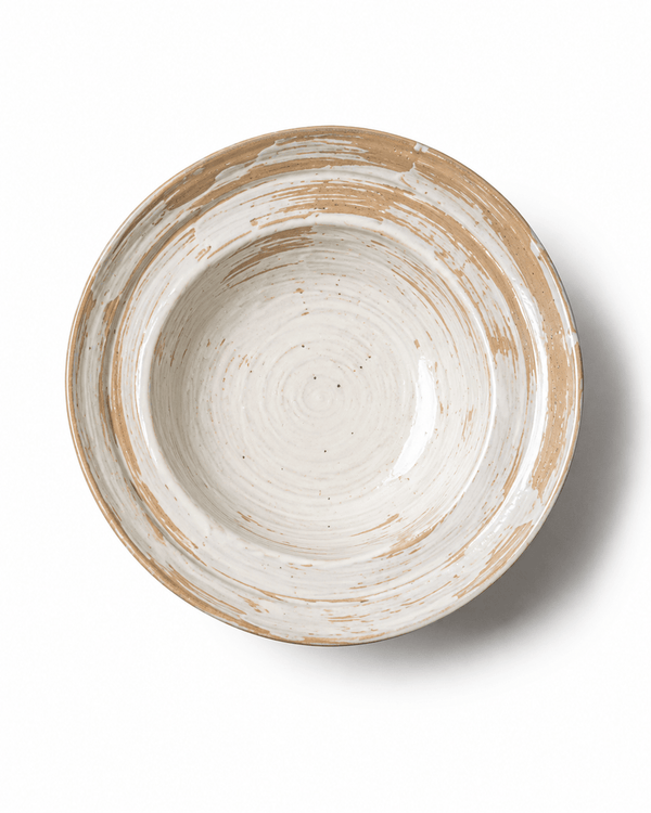 Top view of a handmade rustic ceramic serving bowl with white and beige brushed glaze and natural pottery texture