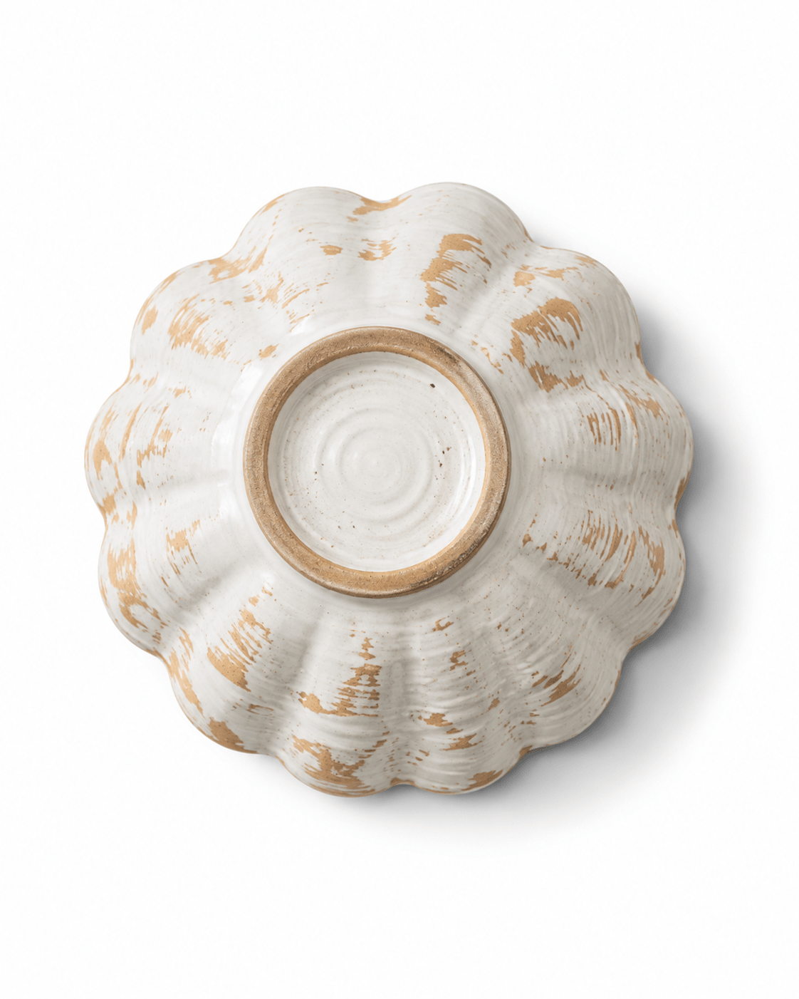 Bottom view of a handmade scalloped ceramic bowl showing the raised foot ring and natural handcrafted glaze variation