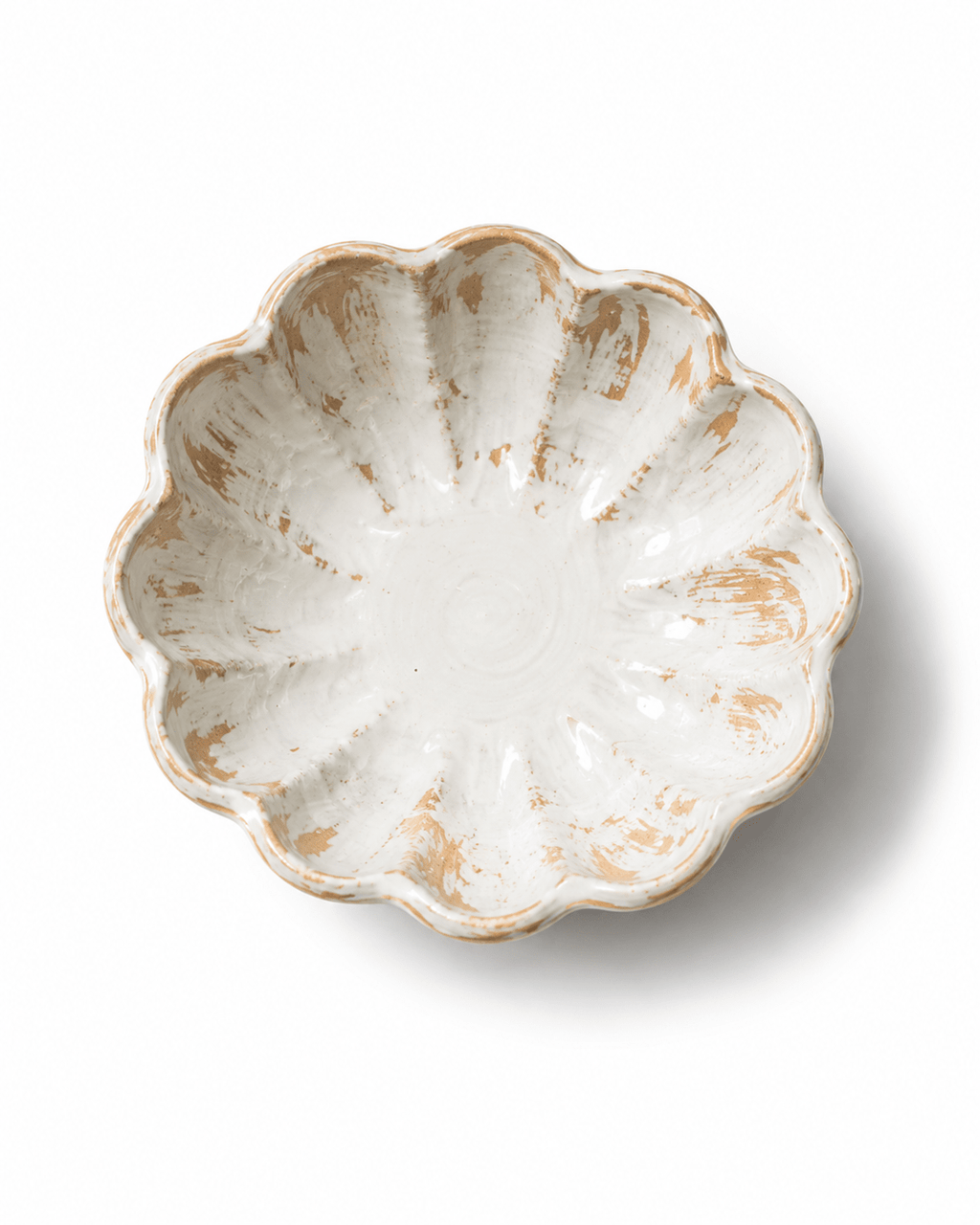 Top view of a handmade scalloped ceramic bowl with a flower-shaped rim and rustic white and beige glaze
