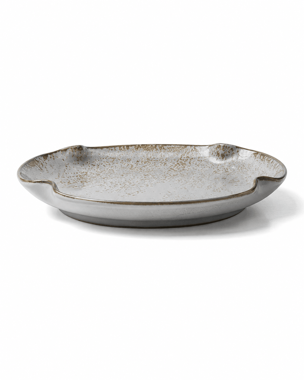 Side view of handmade grey white speckled ceramic dinner plate with reactive glaze, shallow profile and irregular rim