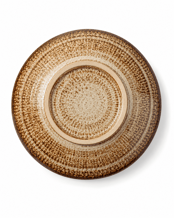 Bottom view of handmade speckled ceramic pasta bowl showing the circular foot ring and natural brown reactive glaze pattern