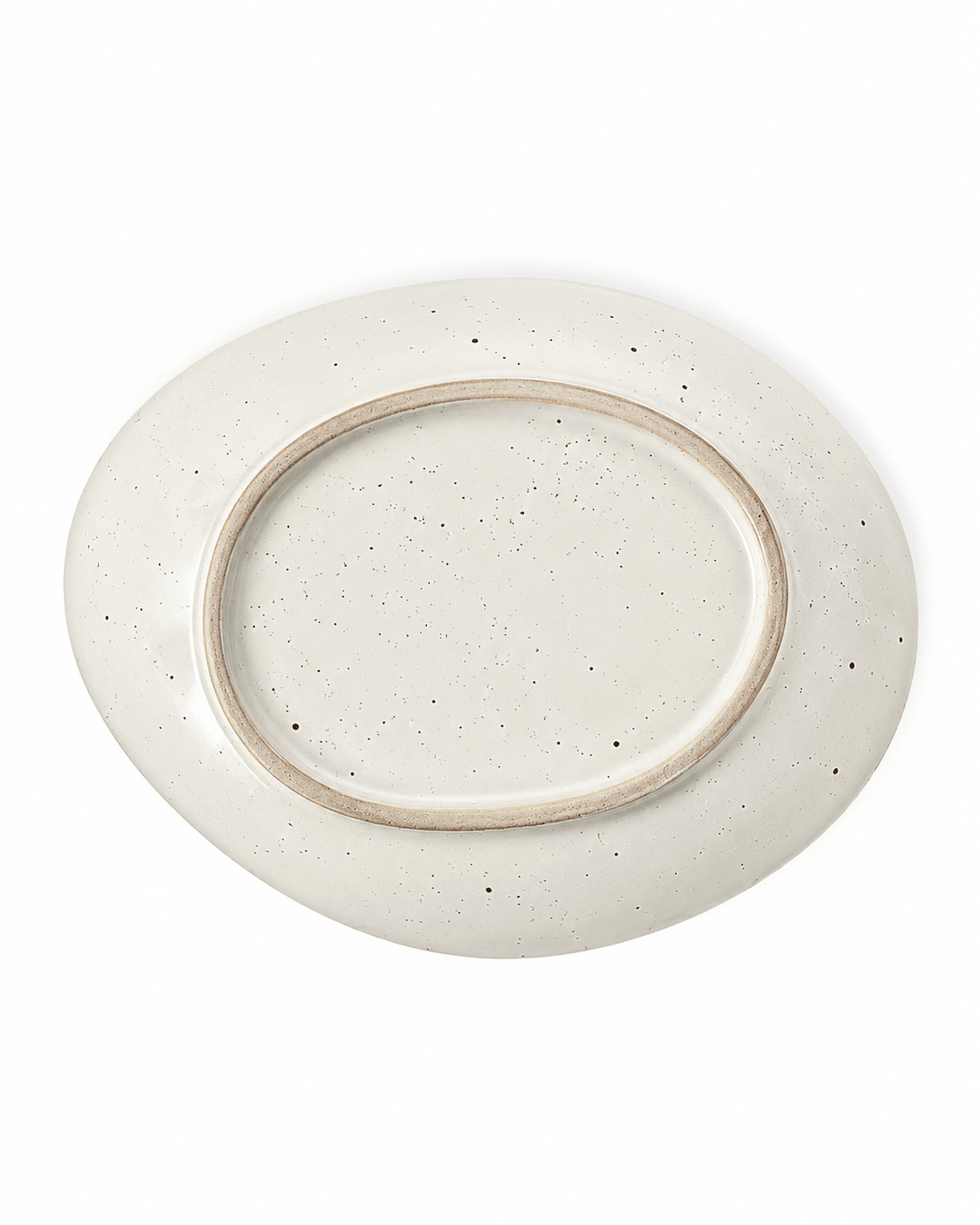 Bottom view of a handmade speckled ceramic plate with an irregular oval shape, off-white glaze and natural unglazed foot ring