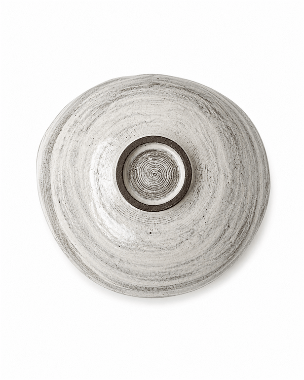 Base view of handmade speckled ceramic serving bowl showing circular foot and natural glaze texture