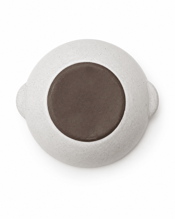 Bottom view of handmade speckled ceramic serving bowl showing the unglazed dark clay base