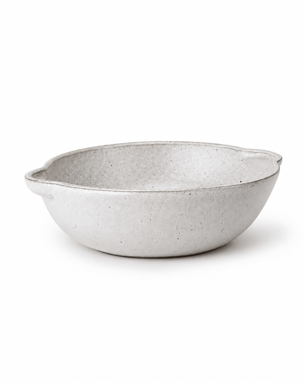 Side view of handmade off-white speckled ceramic serving bowl with double ear handles