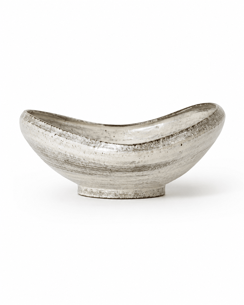 Side view of handmade speckled ceramic serving bowl with reactive glaze and raised foot