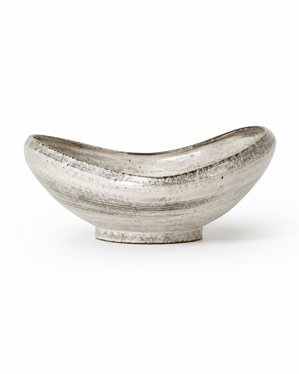 Side view of handmade speckled ceramic serving bowl with reactive glaze and raised foot
