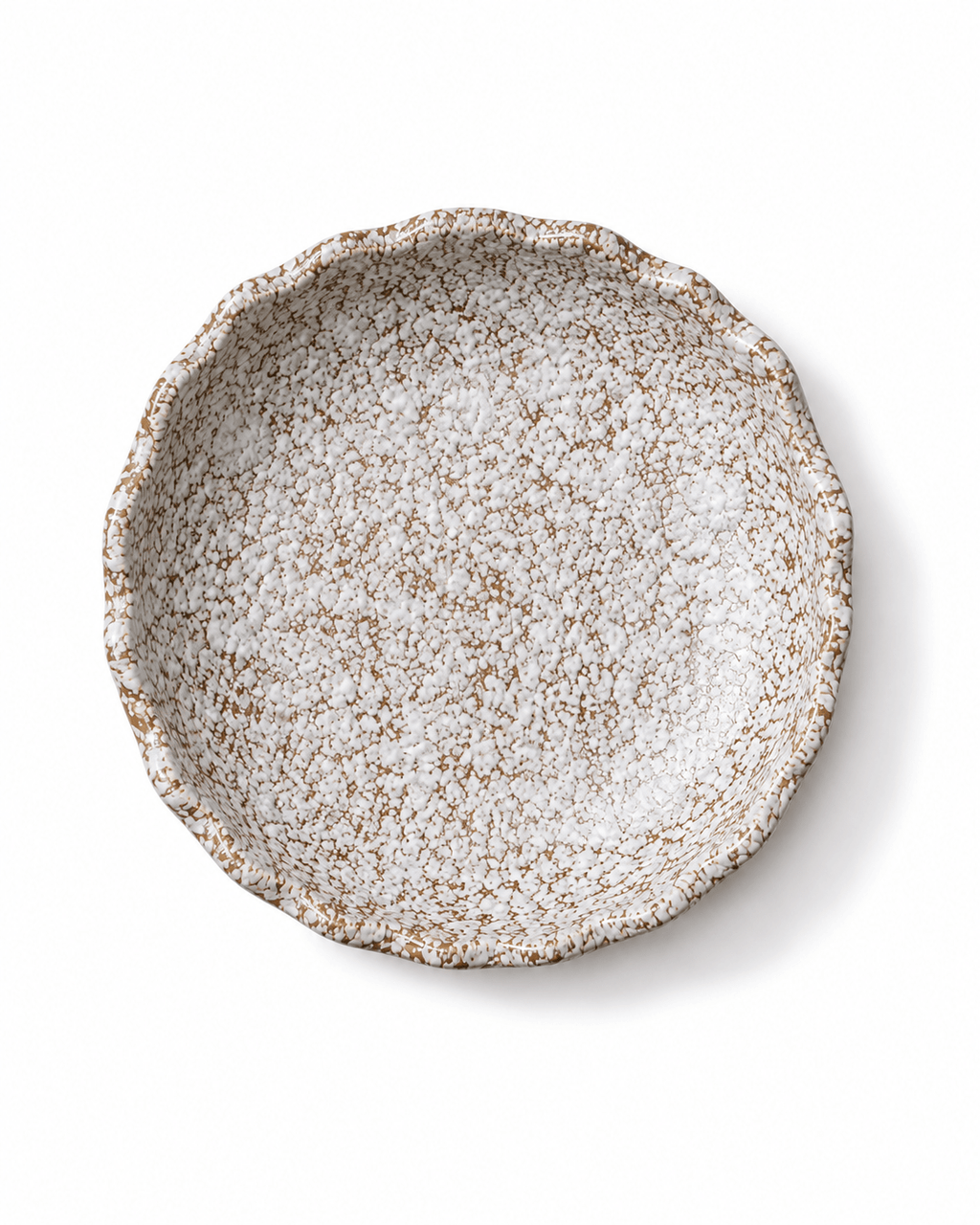 Top view of handmade white and brown speckled ceramic serving bowl with reactive glaze and irregular wavy rim