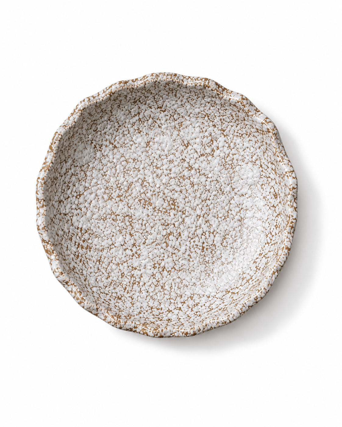 Top view of handmade white and brown speckled ceramic serving bowl with reactive glaze and irregular wavy rim