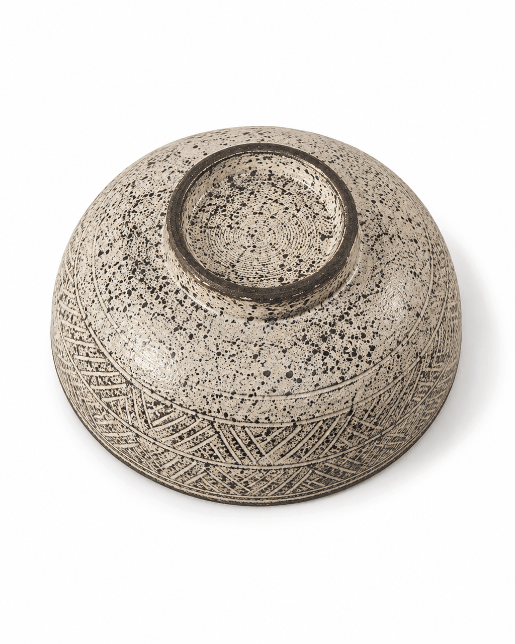 Bottom view of handmade speckled stoneware serving bowl showing foot ring, speckled glaze and carved exterior detail