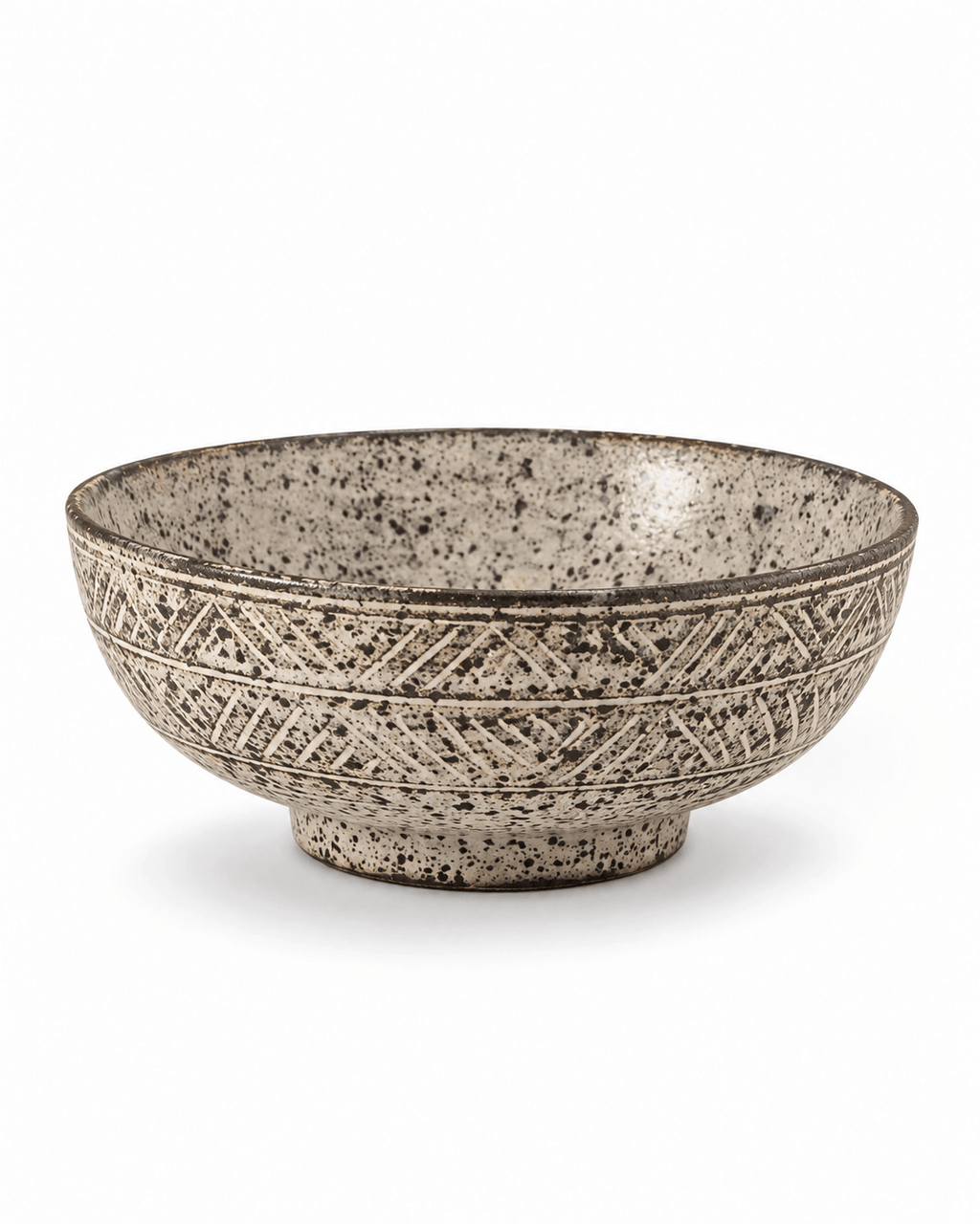 Side view of handmade speckled stoneware serving bowl with carved geometric pattern and rustic dark rim