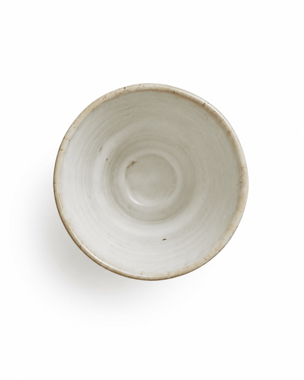 Top view of handmade speckled white stoneware tea cup showing the glazed interior and wheel-thrown texture