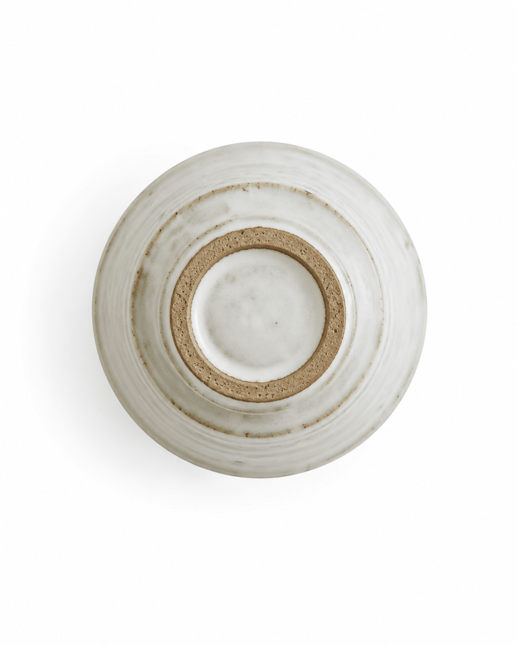 Bottom view of handmade speckled white stoneware yunomi tea cup showing the natural unglazed foot ring
