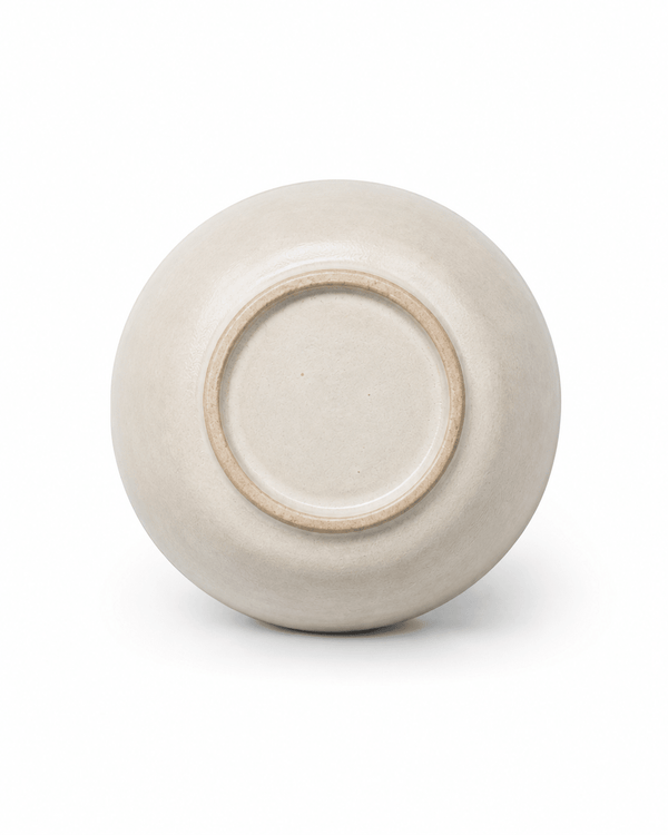 Base detail of handmade off-white stoneware tea cup showing the natural ceramic finish